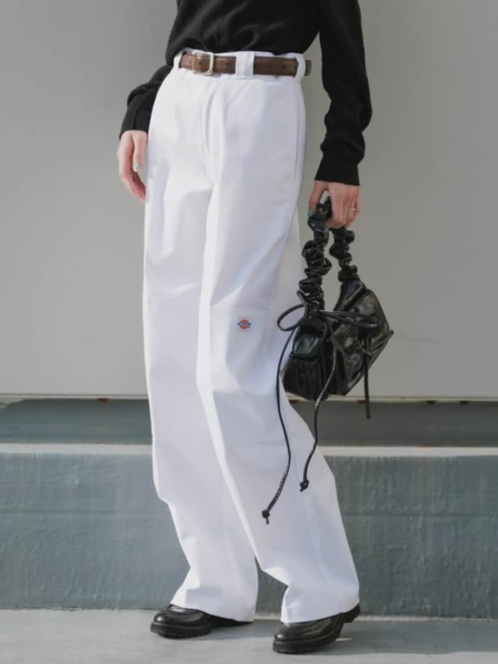 シルバー系のハンドバッグ、ホワイト系のチノパンツ、ブラック系のTシャツ/カットソーを着用したレディースの春コーディネートの3枚目の写真