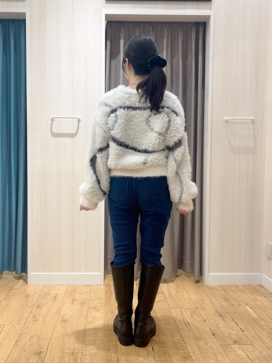 ホワイト系のニット/セーター、ブルー系のその他パンツ、ブラック系のブーツを着用したレディースの冬コーディネートの3枚目の写真