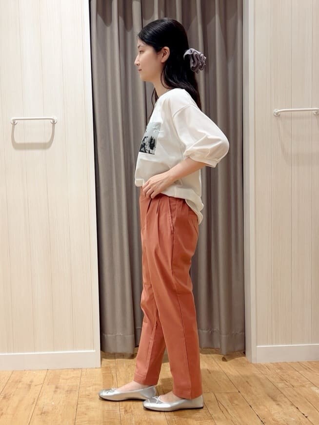 ホワイト系のTシャツ/カットソー、オレンジ系のその他パンツ、シルバー系のその他シューズを着用したレディースの秋コーディネートの2枚目の写真