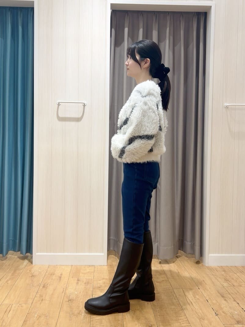 ホワイト系のニット/セーター、ブルー系のその他パンツ、ブラック系のブーツを着用したレディースの冬コーディネートの2枚目の写真