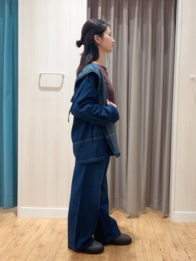 ブルー系のデニムジャケット、ブラウン系のTシャツ/カットソー、ブルー系のデニムパンツを着用したレディースの秋コーディネートの2枚目の写真
