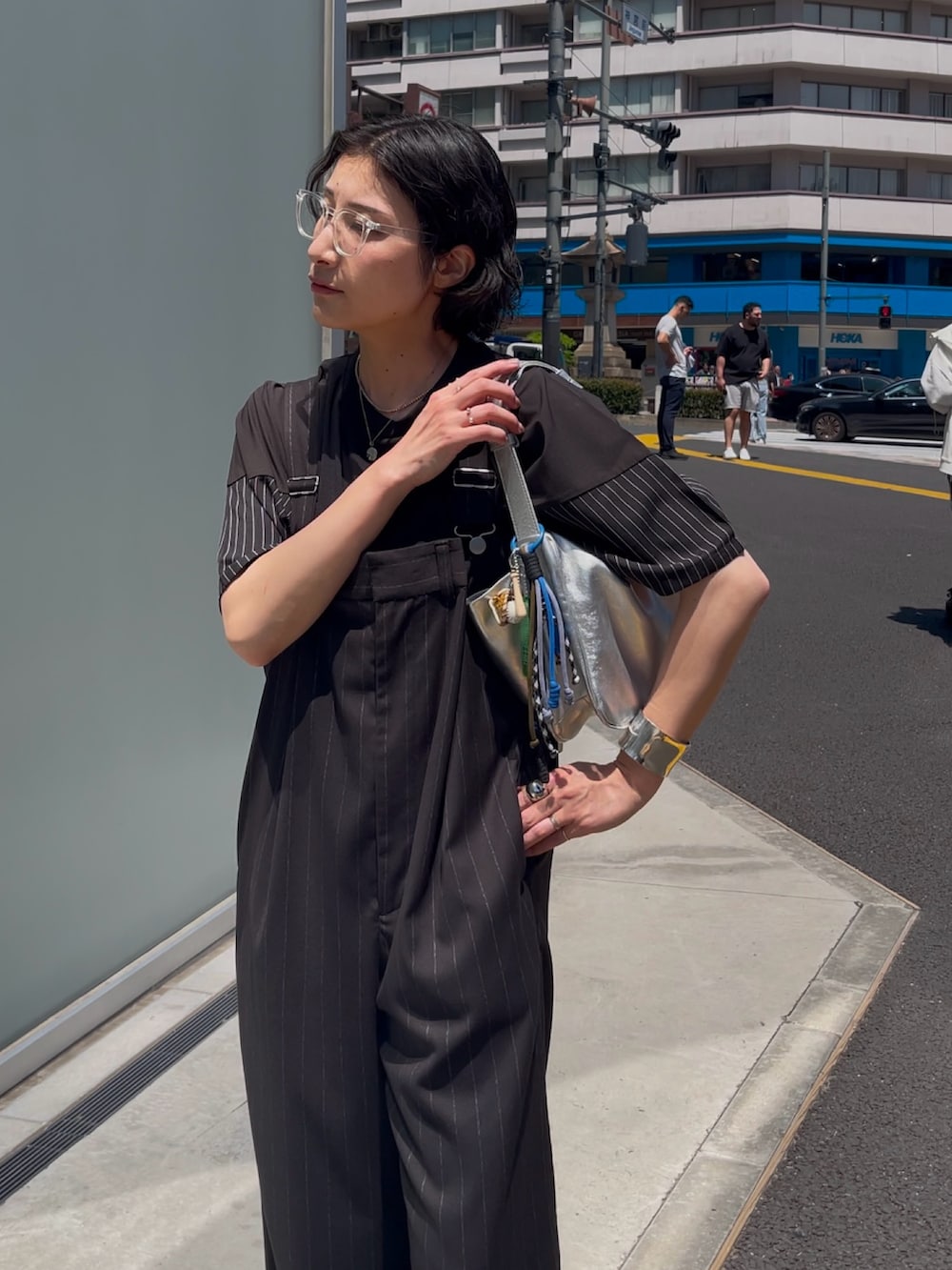 ブラック系のサロペット/オーバーオール、シルバー系のショルダーバッグ、ブラック系のTシャツ/カットソーを着用したレディースの春コーディネートの2枚目の写真