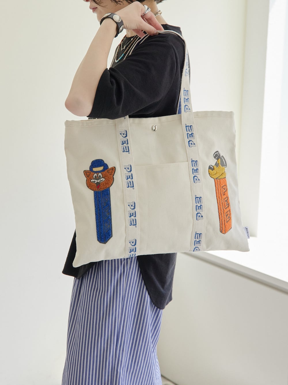 ホワイト系のトートバッグ、ブラック系のTシャツ/カットソー、ブラック系のキーケース/キーアクセサリーを着用したレディースの春コーディネートの4枚目の写真