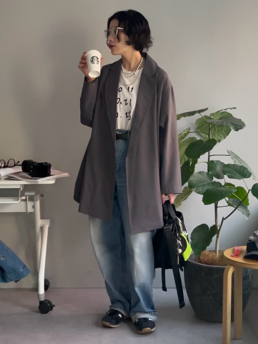 ブラック系のトートバッグ、グレー系のその他アウター、シルバー系のチャームを着用したレディースの春コーディネートの4枚目の写真