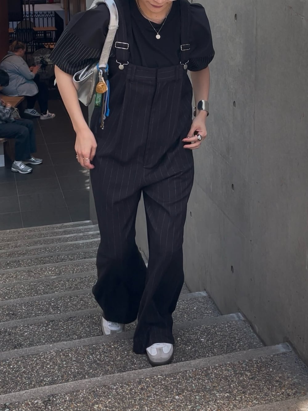 ブラック系のサロペット/オーバーオール、シルバー系のショルダーバッグ、ブラック系のTシャツ/カットソーを着用したレディースの春コーディネートの4枚目の写真