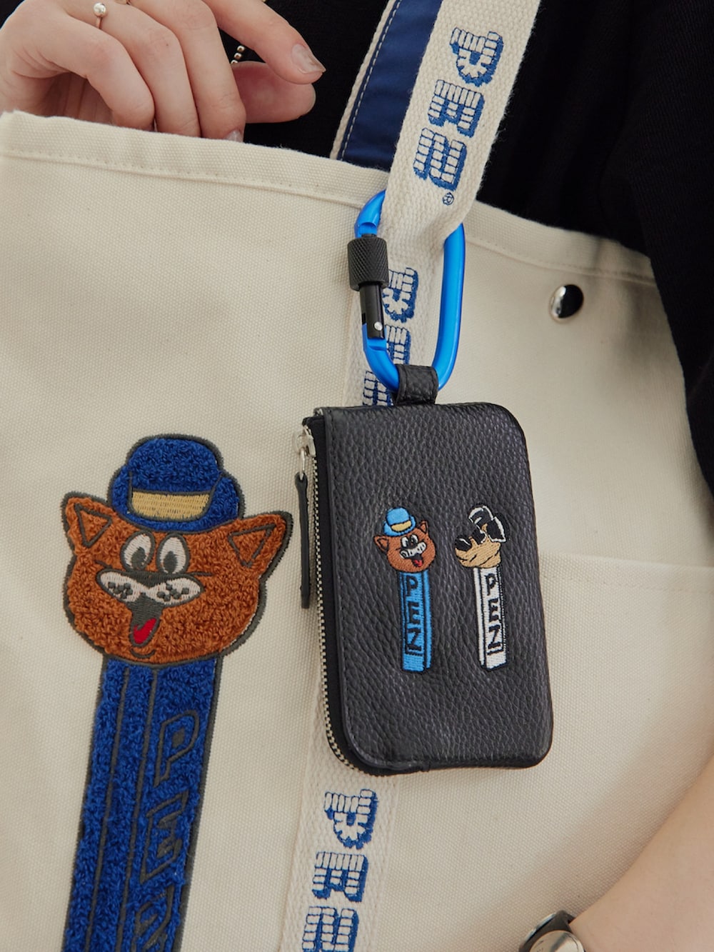 ホワイト系のトートバッグ、ブラック系のTシャツ/カットソー、ブラック系のキーケース/キーアクセサリーを着用したレディースの春コーディネートの6枚目の写真