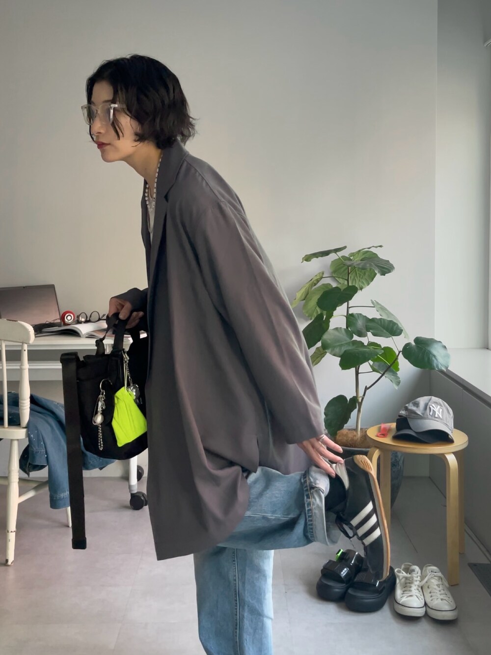 ブラック系のトートバッグ、グレー系のその他アウター、シルバー系のチャームを着用したレディースの春コーディネートの3枚目の写真