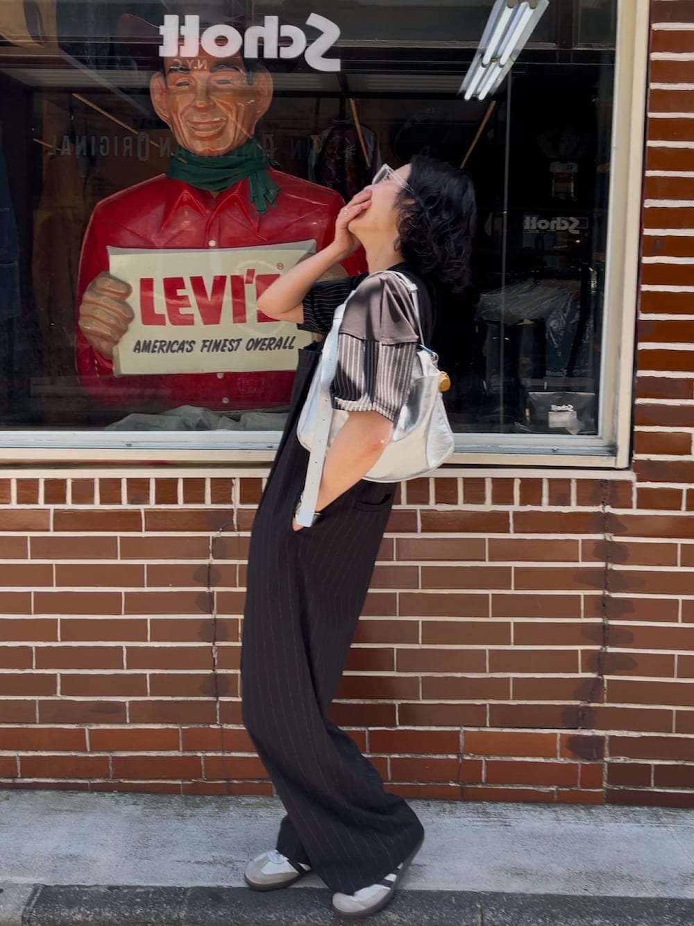 ブラック系のサロペット/オーバーオール、シルバー系のショルダーバッグ、ブラック系のTシャツ/カットソーを着用したレディースの春コーディネートの3枚目の写真