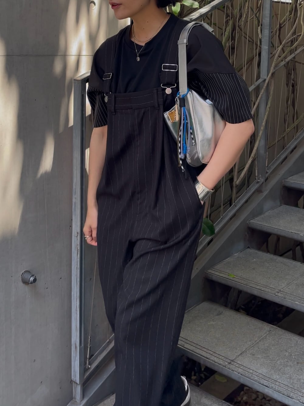ブラック系のサロペット/オーバーオール、シルバー系のショルダーバッグ、ブラック系のTシャツ/カットソーを着用したレディースの春コーディネートの5枚目の写真
