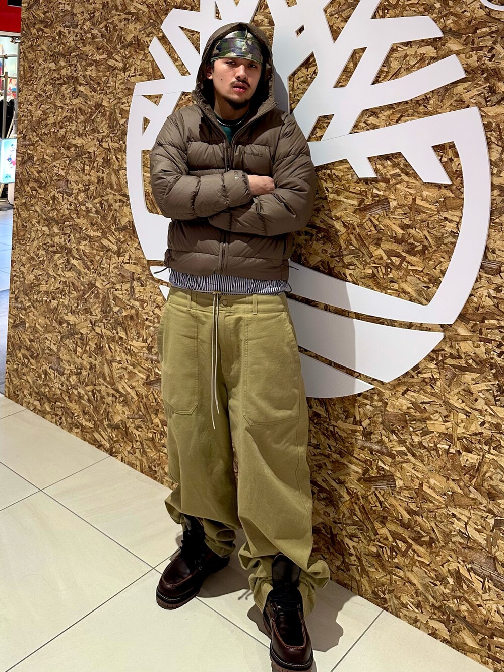 レッド系のブーツ、グリーン系のその他パンツ、グリーン系のTシャツ/カットソーを着用したメンズの冬コーディネートの3枚目の写真