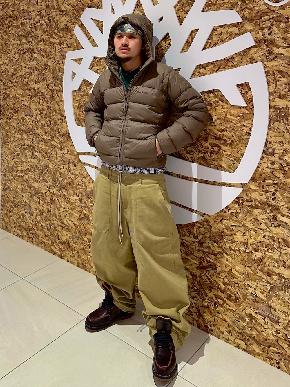 レッド系のブーツ、グリーン系のその他パンツ、グリーン系のTシャツ/カットソーを着用したメンズの冬コーディネートの2枚目の写真