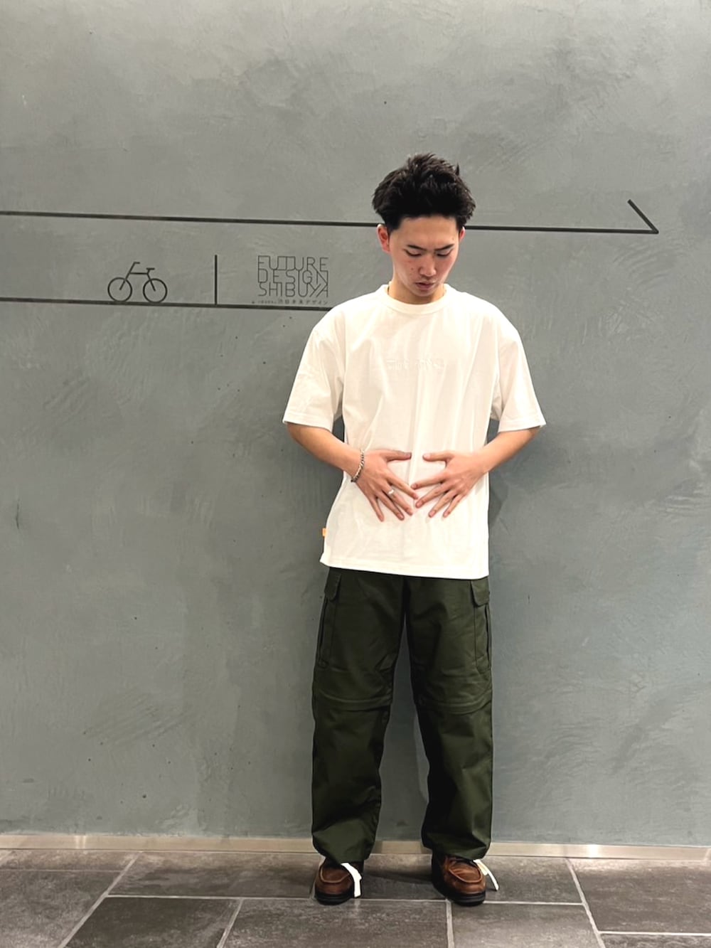 イエロー系のナイロンジャケット、グリーン系のカーゴパンツ、ブラウン系のその他シューズを着用したメンズの冬コーディネートの2枚目の写真