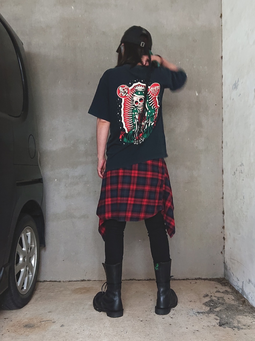 ブラック系のTシャツ/カットソー、ブラック系のデニムパンツ、ブラック系のブーツを着用したレディースの春コーディネートの2枚目の写真