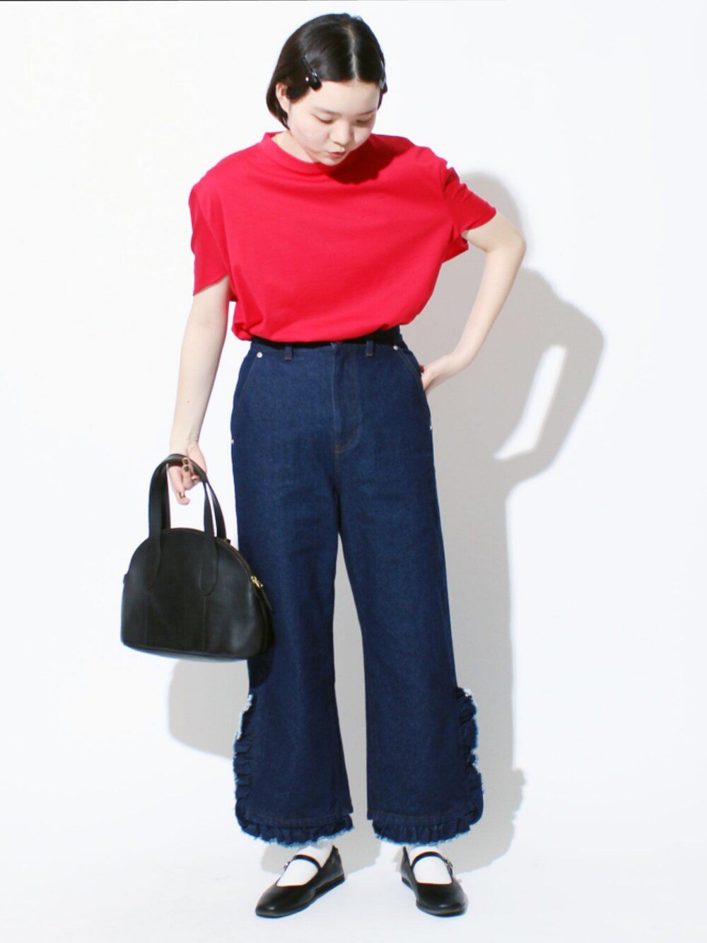 ブルー系のデニムパンツ、ブラック系のデニムパンツ、グリーン系のトートバッグを着用したレディースの冬コーディネートの2枚目の写真