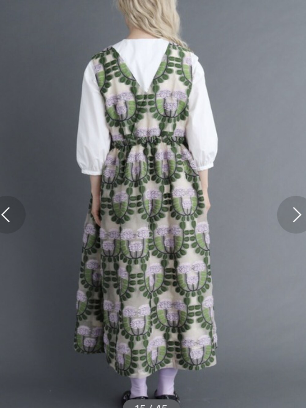 オレンジ系のワンピース、ホワイト系のシャツ/ブラウスを着用したレディースの春コーディネートの2枚目の写真