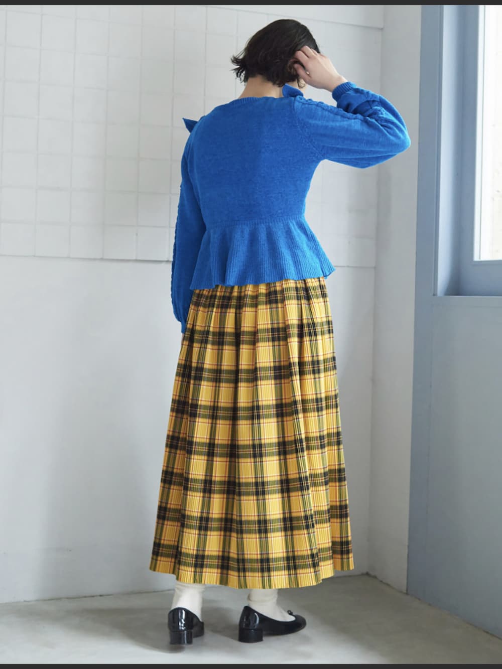 レッド系のスカート、ブルー系のニット/セーターを着用したレディースの夏コーディネートの2枚目の写真