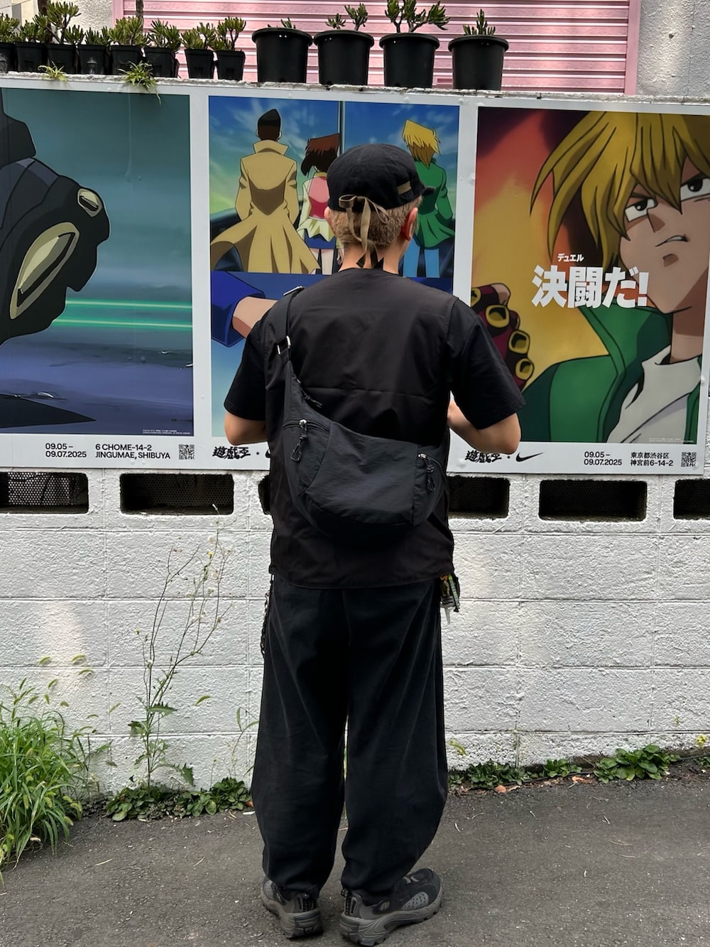 ブラック系のスニーカー、ブラック系のパンツ、ブラック系のベストを着用したメンズの夏コーディネートの2枚目の写真