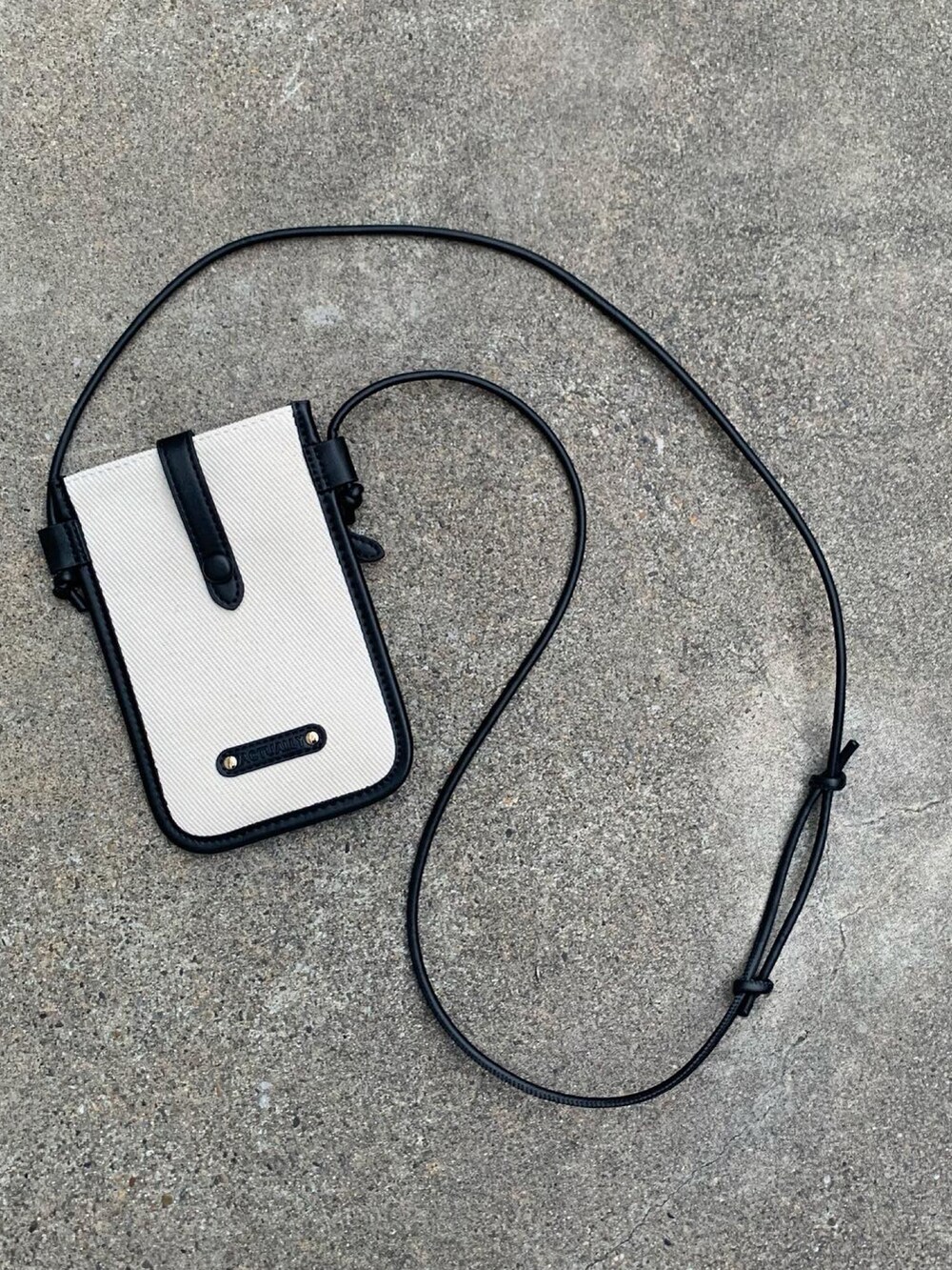 ブラック系のショルダーバッグ、ブラック系のスウェット、ベージュ系のパンツを着用したメンズの冬コーディネートの2枚目の写真