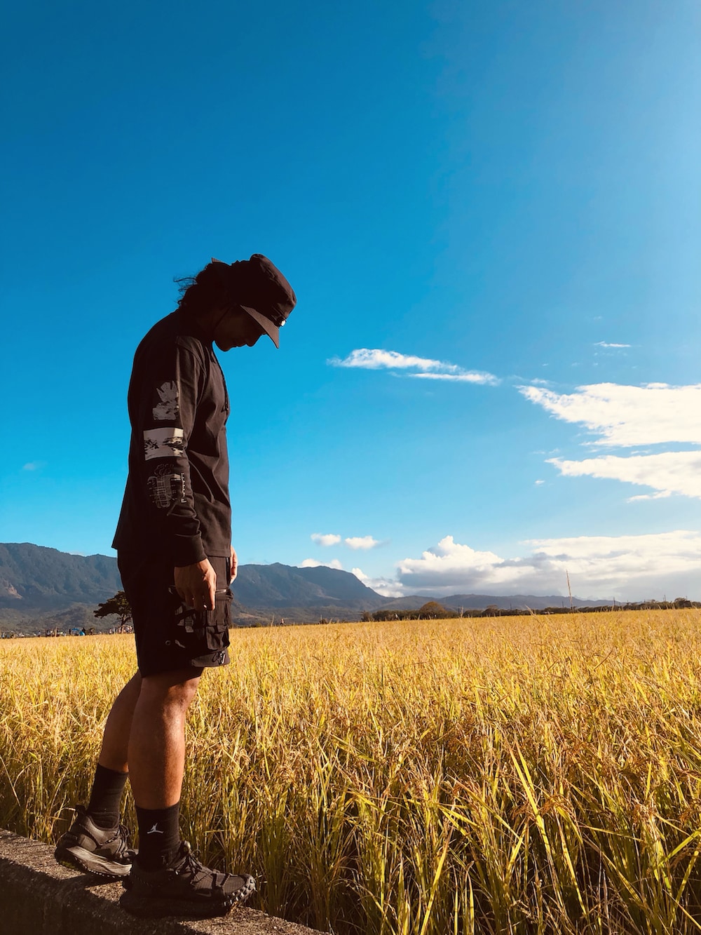 ブラック系のTシャツ/カットソー、ブラック系のカーゴパンツ、ブラック系のスニーカーを着用したメンズの秋コーディネートの2枚目の写真