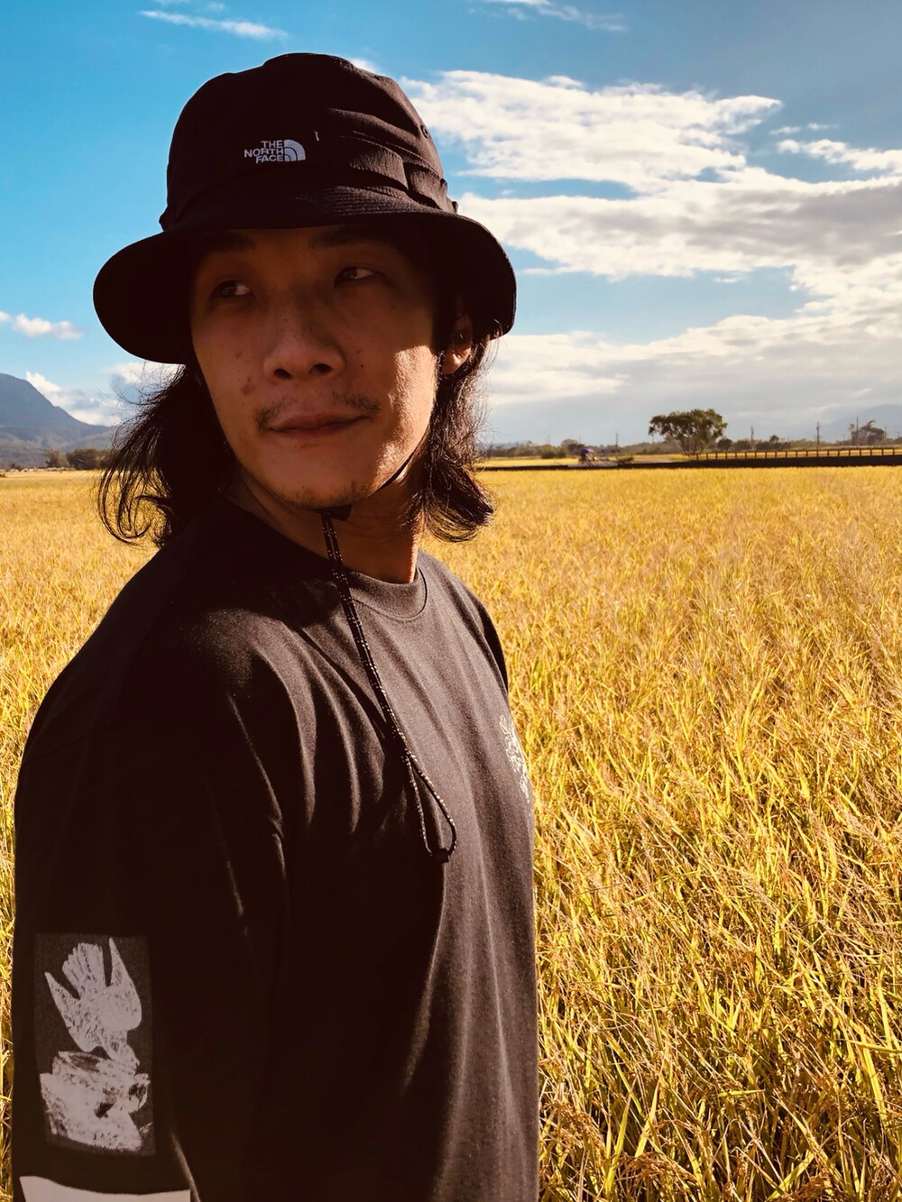 ブラック系のTシャツ/カットソー、ブラック系のカーゴパンツ、ブラック系のスニーカーを着用したメンズの秋コーディネートの4枚目の写真