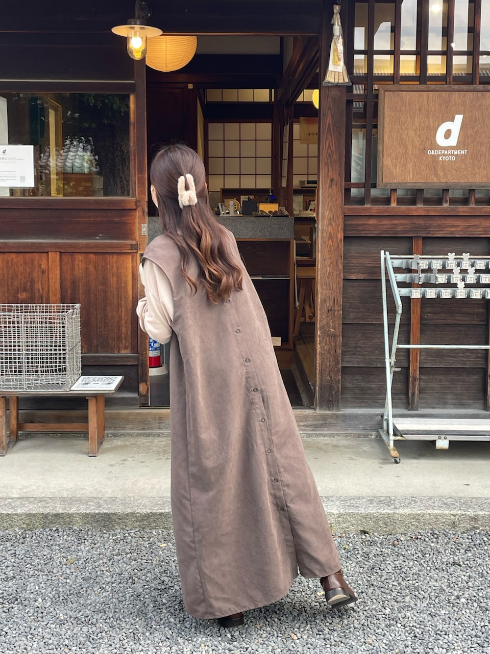 ブラウン系のワンピース、ベージュ系のニット/セーター、ブラウン系のブーツを着用したレディースの秋コーディネートの2枚目の写真