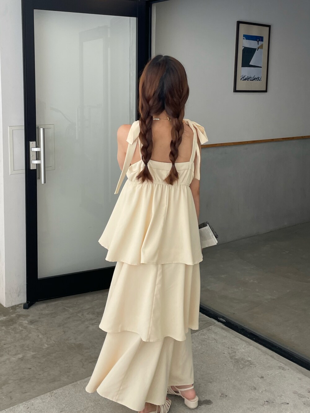 ホワイト系のサンダル、イエロー系のワンピース、ベージュ系のかごバッグを着用したレディースの夏コーディネートの3枚目の写真