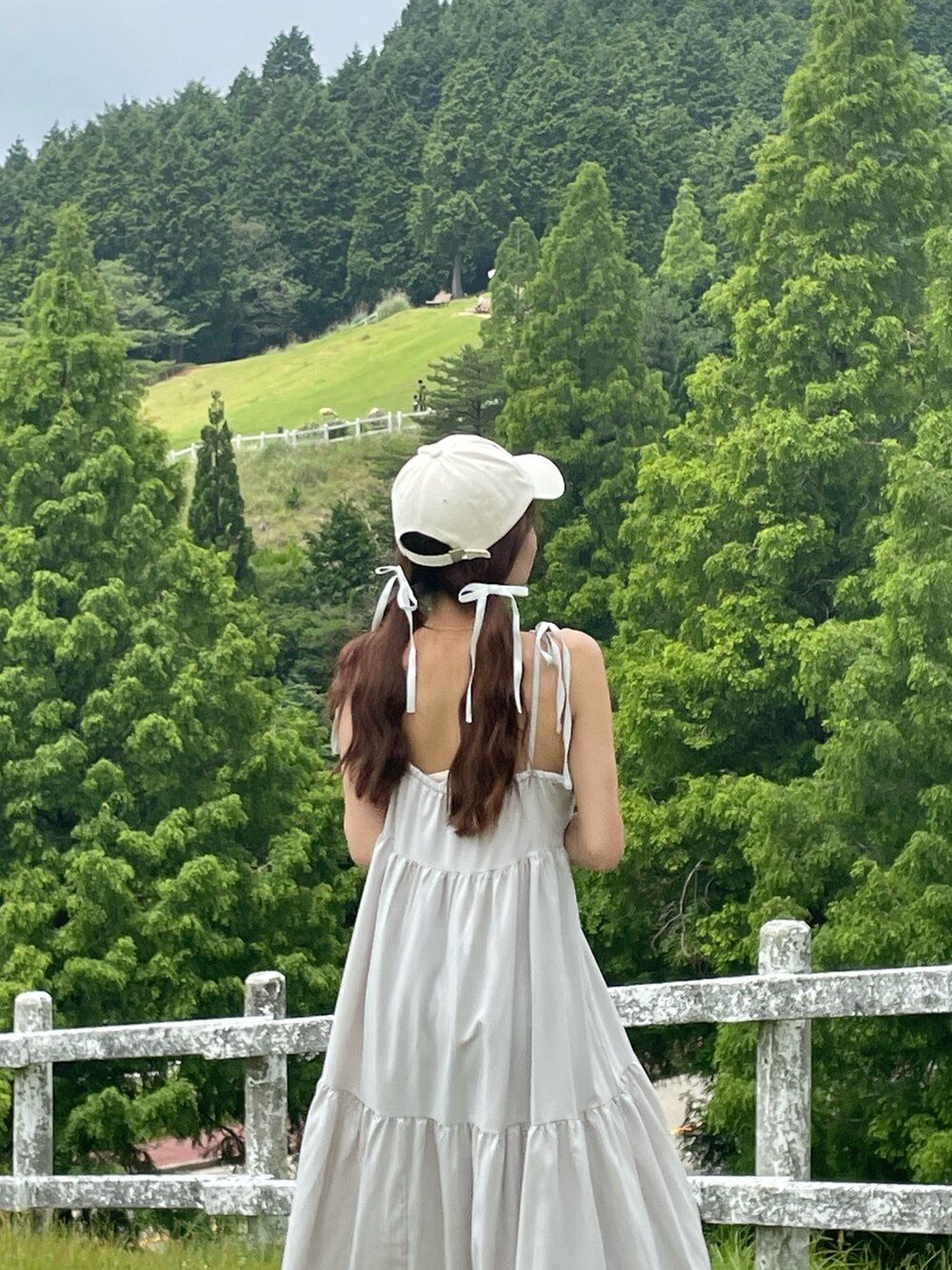 グレー系のワンピースを着用したレディースの夏コーディネートの4枚目の写真