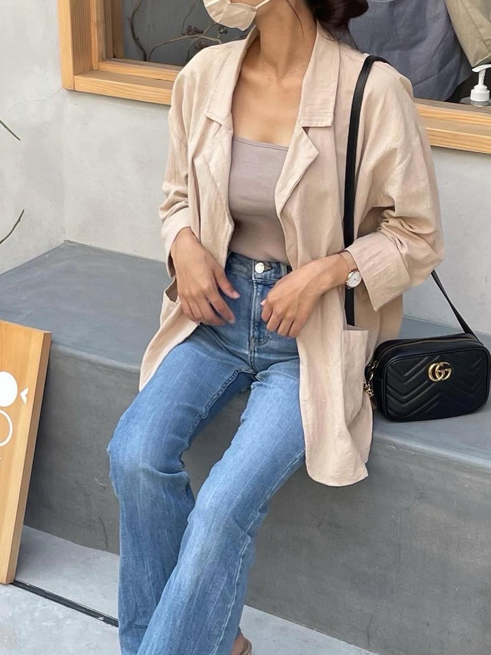 ベージュ系のキャミソール、ブルー系のデニムパンツ、ベージュ系のサンダルを着用したレディースの秋コーディネートの3枚目の写真