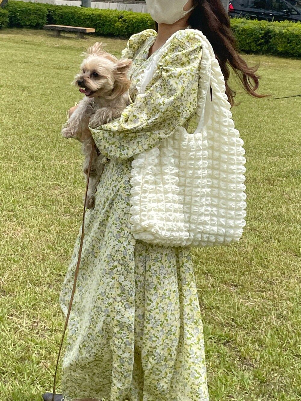 ホワイト系のトートバッグ、イエロー系のワンピース、ブラウン系のローファーを着用したレディースの夏コーディネートの2枚目の写真