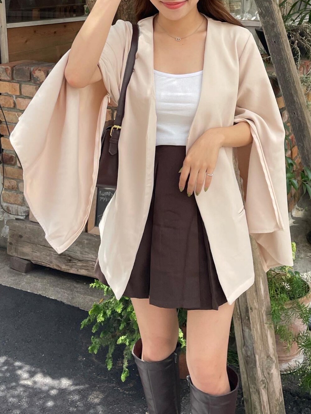 ブラウン系のスカート、ホワイト系のノーカラージャケット、ブラウン系のブーツを着用したレディースの秋コーディネートの4枚目の写真