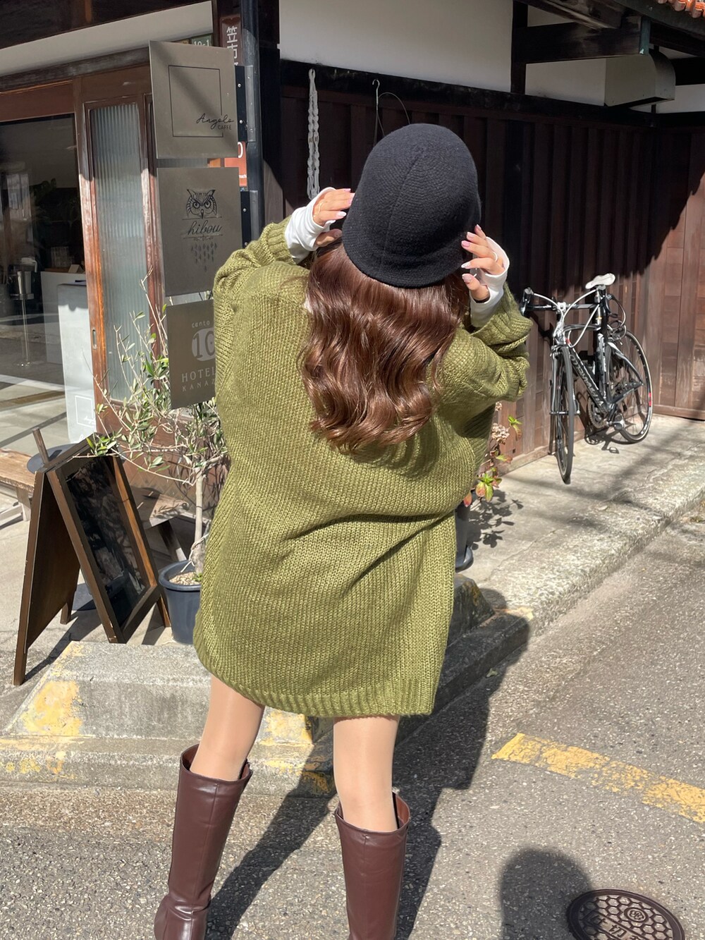 グリーン系のニット/セーター、ホワイト系のTシャツ/カットソー、ブラウン系のブーツを着用したレディースの秋コーディネートの3枚目の写真