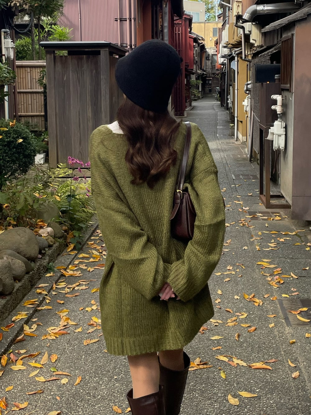 グリーン系のニット/セーター、ホワイト系のTシャツ/カットソー、ブラウン系のブーツを着用したレディースの秋コーディネートの4枚目の写真