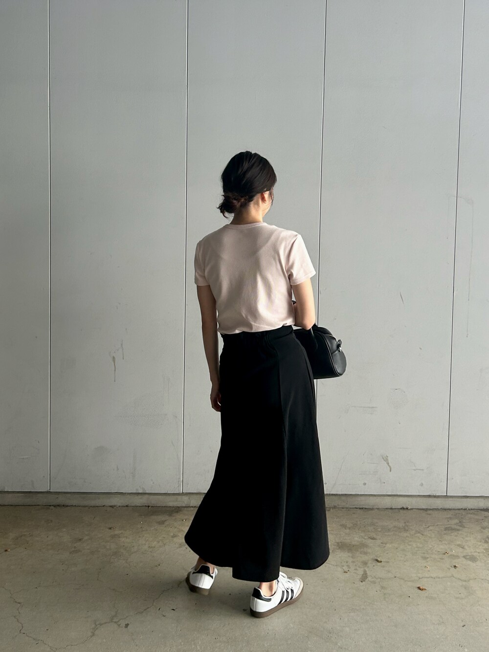 ホワイト系のスニーカー、ピンク系のTシャツ/カットソー、ブラック系のスカートを着用したレディースの夏コーディネートの3枚目の写真