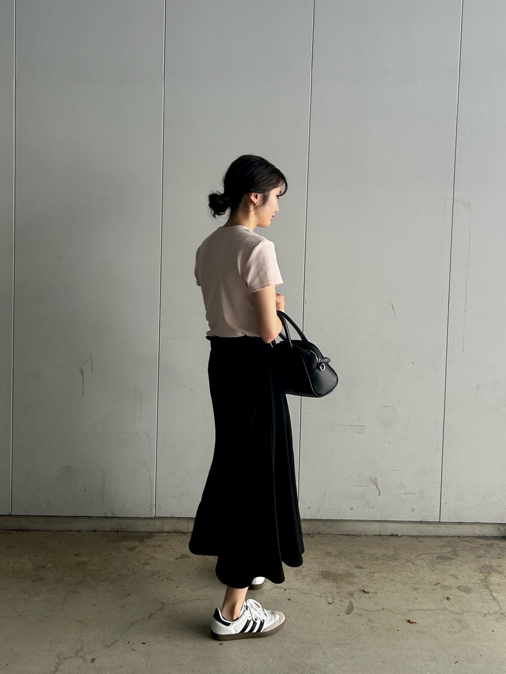ホワイト系のスニーカー、ピンク系のTシャツ/カットソー、ブラック系のスカートを着用したレディースの夏コーディネートの2枚目の写真
