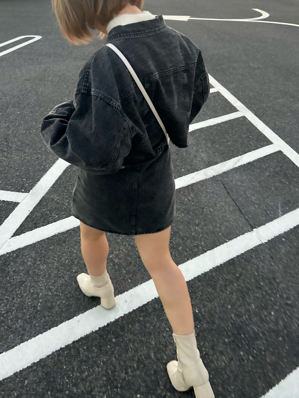 ブラック系のデニムスカート、ブラック系のデニムジャケット、ベージュ系のニット/セーターを着用したレディースの冬コーディネートの3枚目の写真