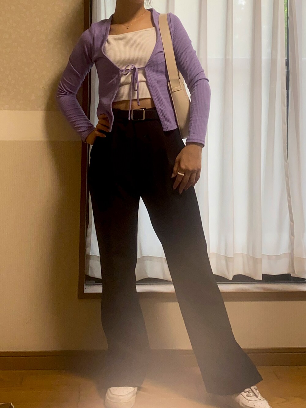 パープル系のトップス、ブラック系のパンツ、ホワイト系のスニーカーを着用したレディースの秋コーディネートの2枚目の写真