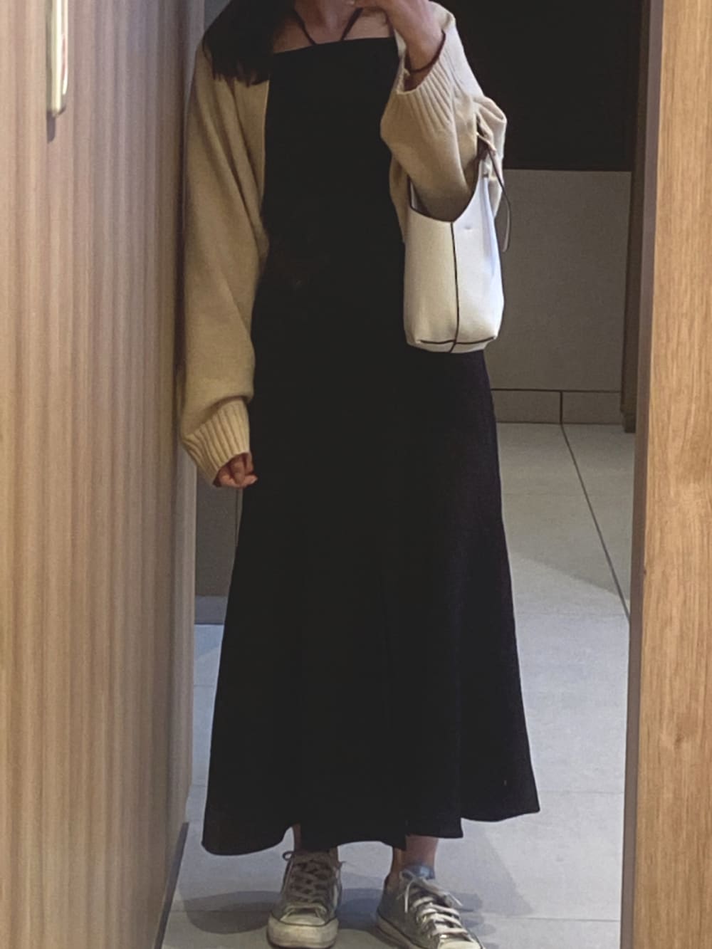 ホワイト系のハンドバッグ、シルバー系のスニーカー、ブラック系のワンピース/ドレスを着用したレディースの冬コーディネートの2枚目の写真