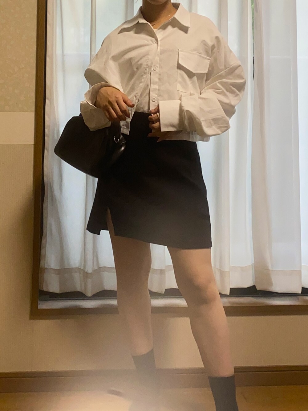 ホワイト系のシャツ/ブラウス、ブラック系のハンドバッグ、ブラック系のスカートを着用したレディースの秋コーディネートの2枚目の写真