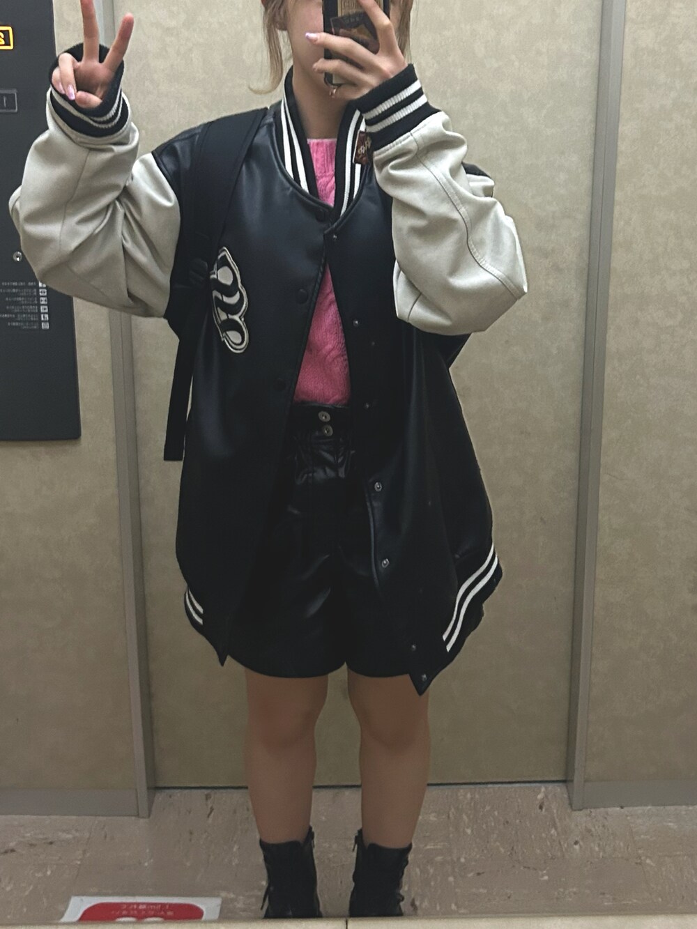 ブラック系のブーツ、ブラック系のパンツ、ピンク系のニット/セーターを着用したレディースの冬コーディネートの2枚目の写真