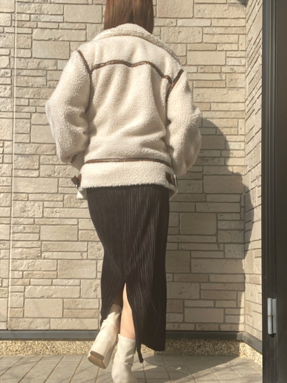 ホワイト系のその他アウター、ブラック系のスカート、ホワイト系のブーツを着用したレディースの冬コーディネートの2枚目の写真