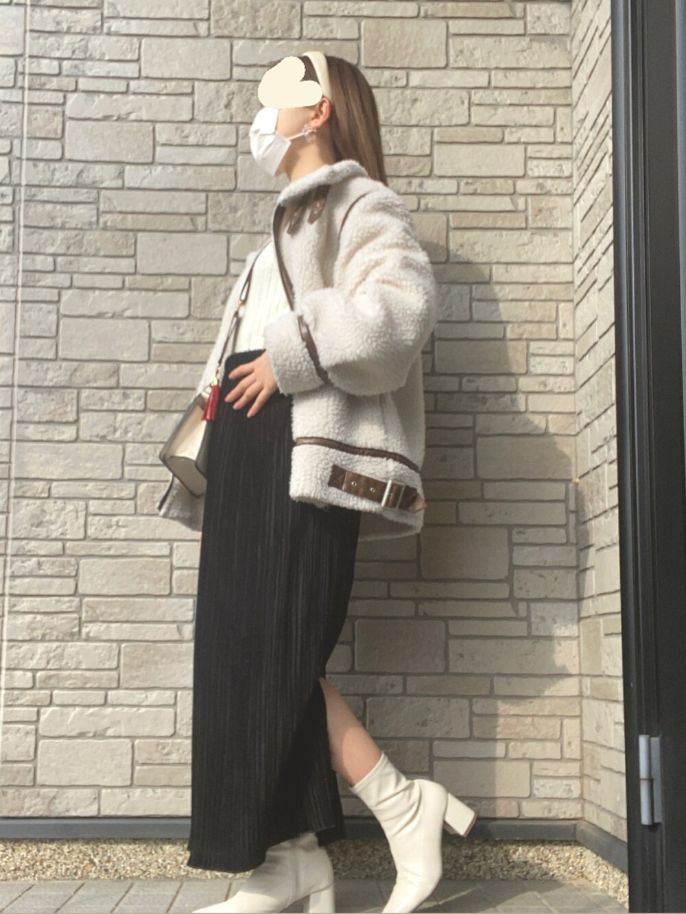 ホワイト系のその他アウター、ブラック系のスカート、ホワイト系のブーツを着用したレディースの冬コーディネートの3枚目の写真
