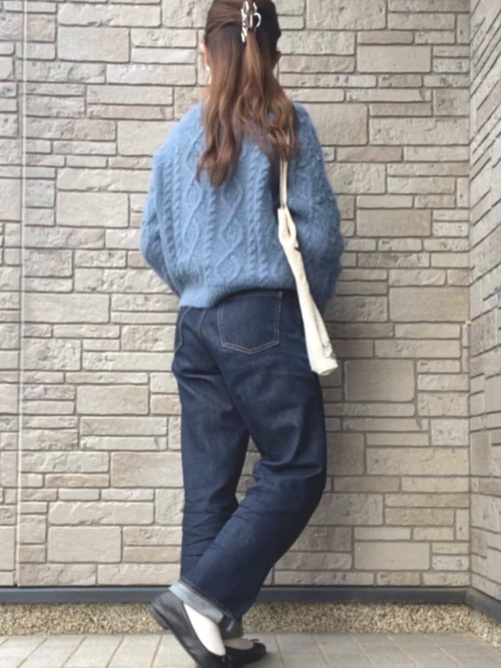 ブルー系のカーディガン/ボレロ、ホワイト系のエコバッグ/サブバッグ、ブルー系のデニムパンツを着用したレディースの冬コーディネートの2枚目の写真