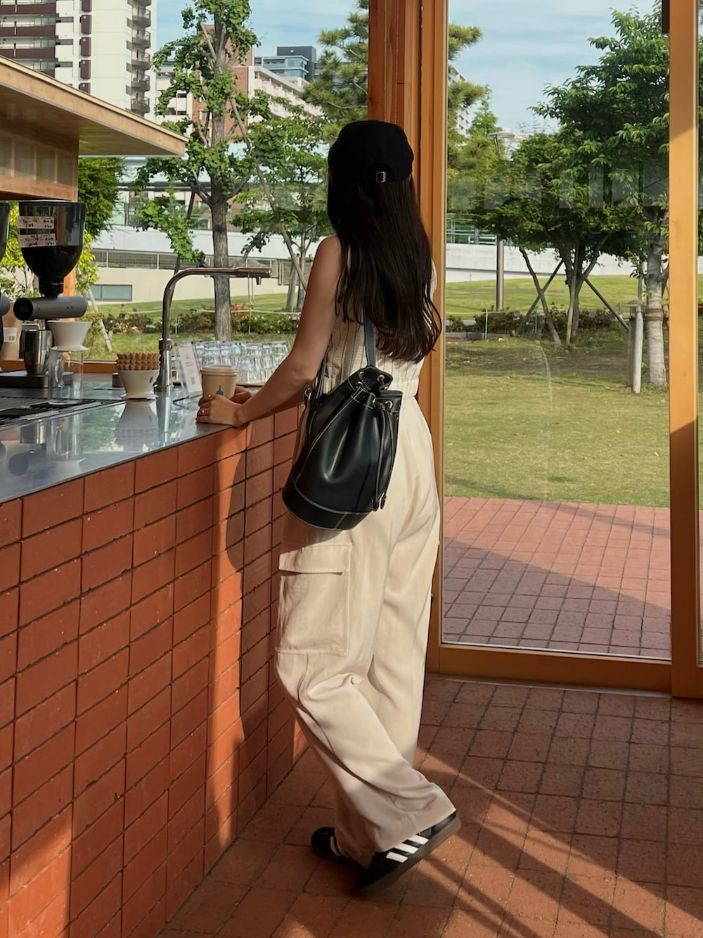 ホワイト系のカーゴパンツ、ブラック系のスニーカー、ブラック系のハンチング/ベレー帽を着用したレディースの春コーディネートの3枚目の写真