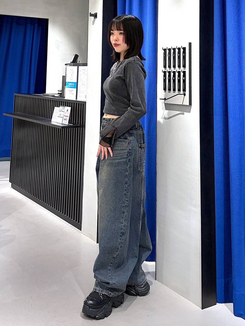 ブラック系のブーツ、ブルー系のデニムパンツ、グレー系のTシャツ/カットソーを着用したレディースの春コーディネートの4枚目の写真