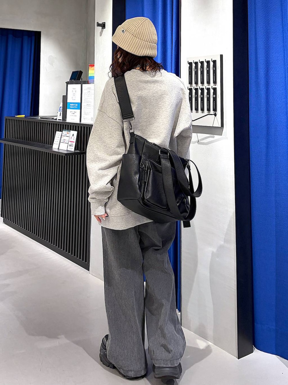 ブラック系のブーツ、ブラック系のボストンバッグ、ブラック系のデニムパンツを着用したレディースの冬コーディネートの3枚目の写真