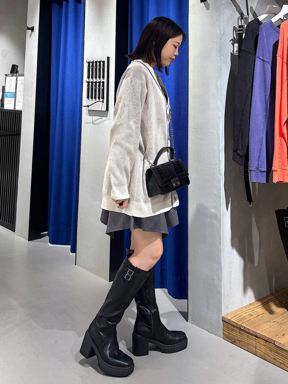 ブラック系のキャミソール、グレー系のスカート、ブラック系のハンドバッグを着用したレディースの秋コーディネートの2枚目の写真