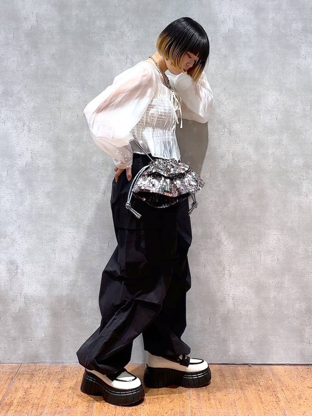 ブラック系のカーゴパンツ、ホワイト系のシャツ/ブラウス、ブラック系のキャミソールを着用したレディースの春コーディネートの2枚目の写真