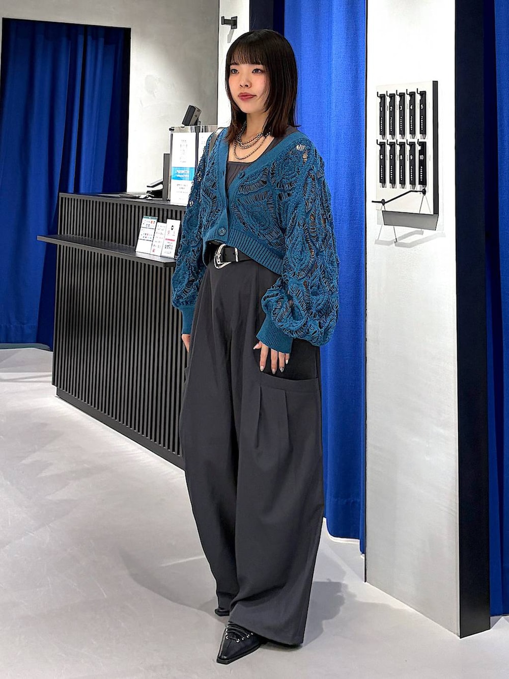 ブルー系のカーディガン/ボレロ、グレー系のタンクトップ、ブラック系のサンダルを着用したレディースの春コーディネートの4枚目の写真