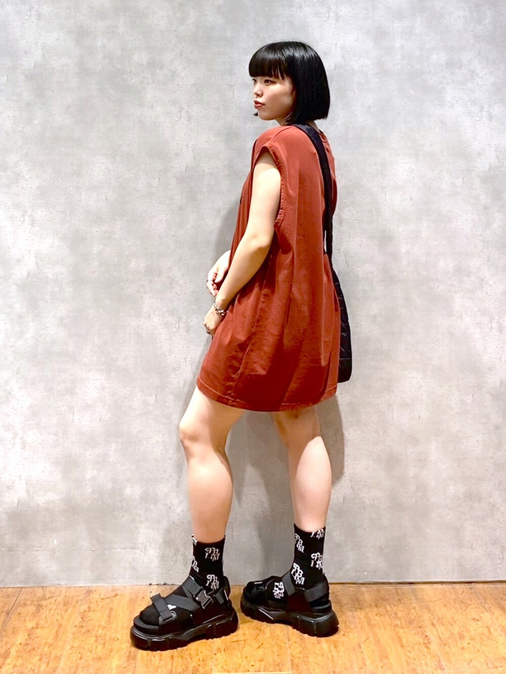 レッド系のTシャツ/カットソー、ブラック系のショルダーバッグ、ブラック系のその他パンツを着用したレディースの夏コーディネートの4枚目の写真