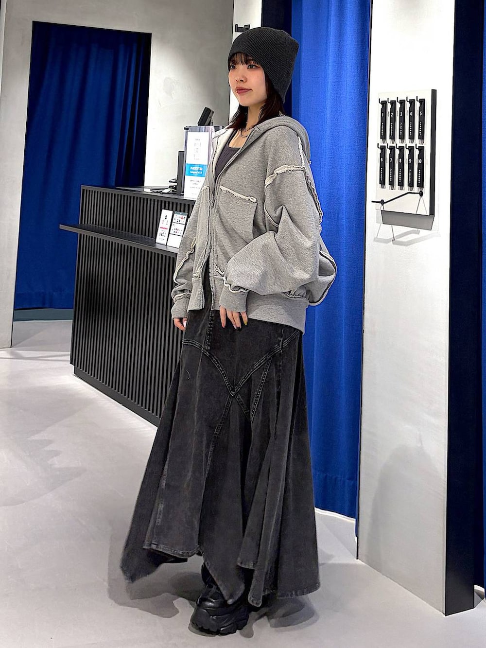 ブラック系のスニーカー、ブラック系のデニムスカート、グレー系のタンクトップを着用したレディースの春コーディネートの4枚目の写真